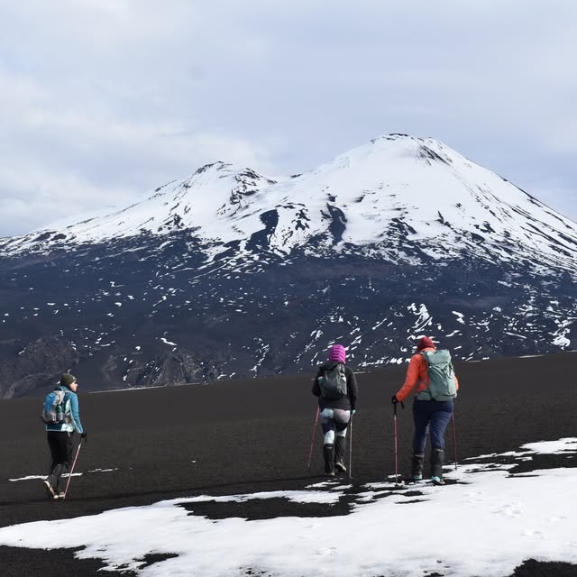Excursionistas de Ñamku Adventure avanzando frente al volcán Llaima