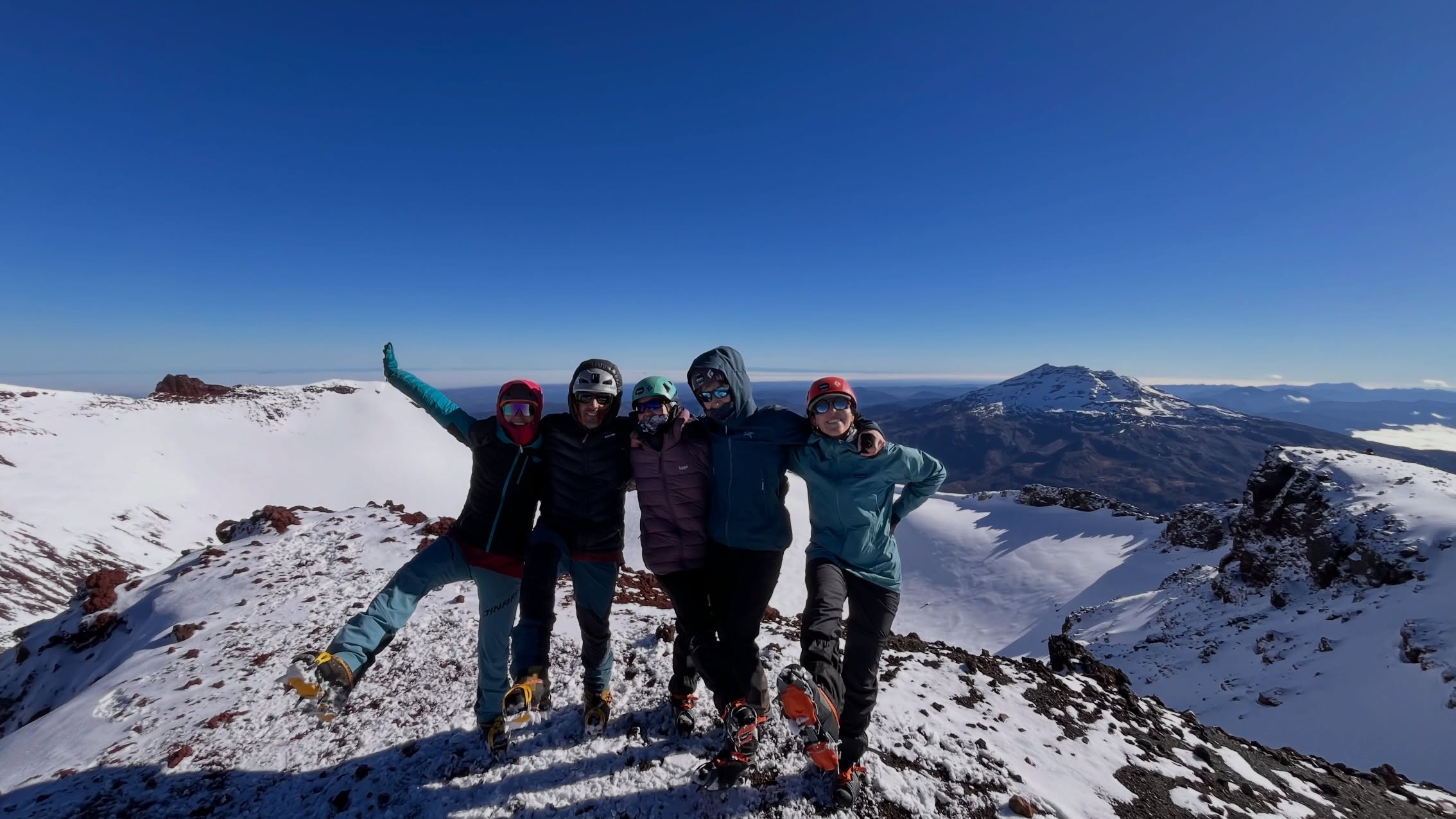 Grupo de excursionistas en una cumbre nevada de la Araucanía